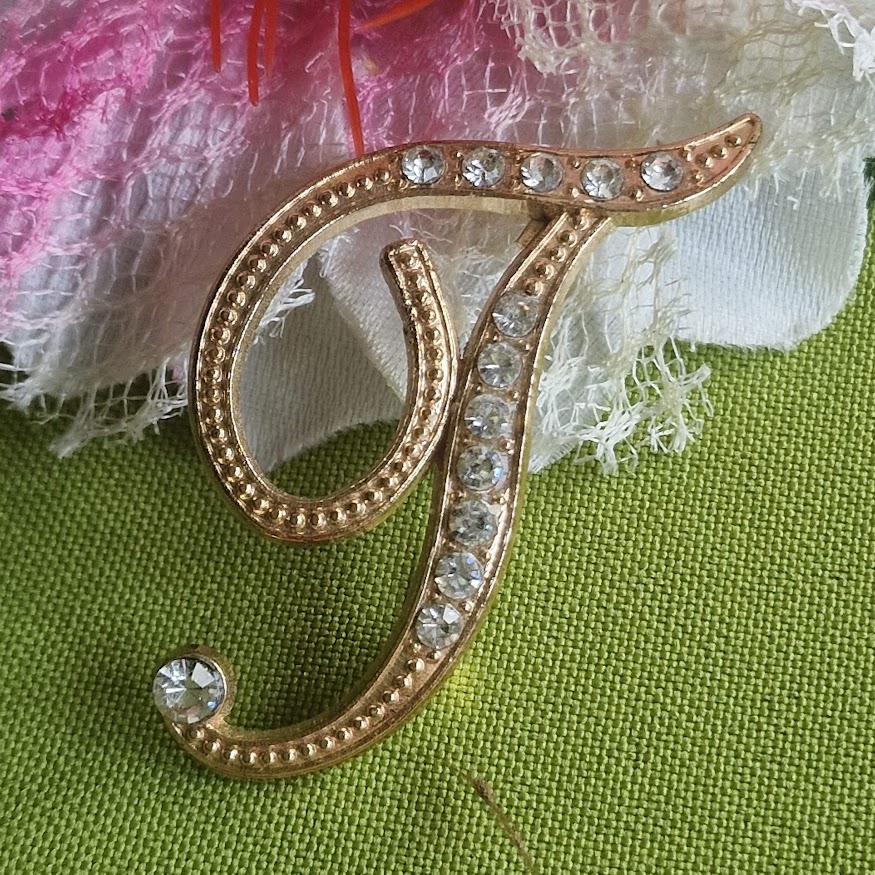 Kitűző bross BRO319 - Strasszköves T betű arany színű alapon 40x50mm